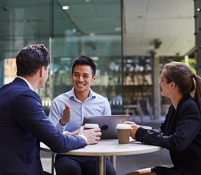 Business professionals discussing cloud strategy during an outdoor meeting.