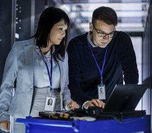 IT professionals conducting an infrastructure assessment in a server room.