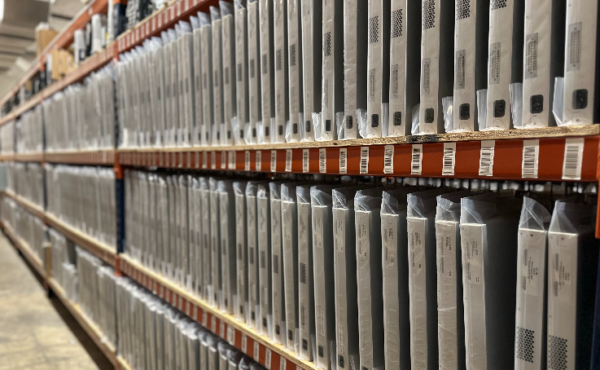 Warehouse shelves filled with packaged network hardware equipment.